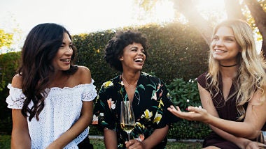 three women talking and laughing outside
