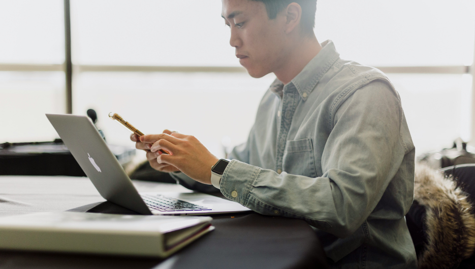asian-man-on-phone-laptop-935x530px