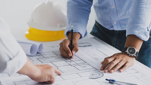 engineer meeting for an architectural project. working with partner and engineering tools working on blueprint architectural project at the construction site at desk in the office.