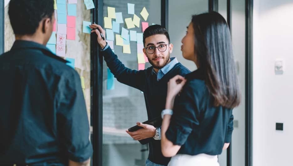 Multicultural creative employees collaborating on creating prese